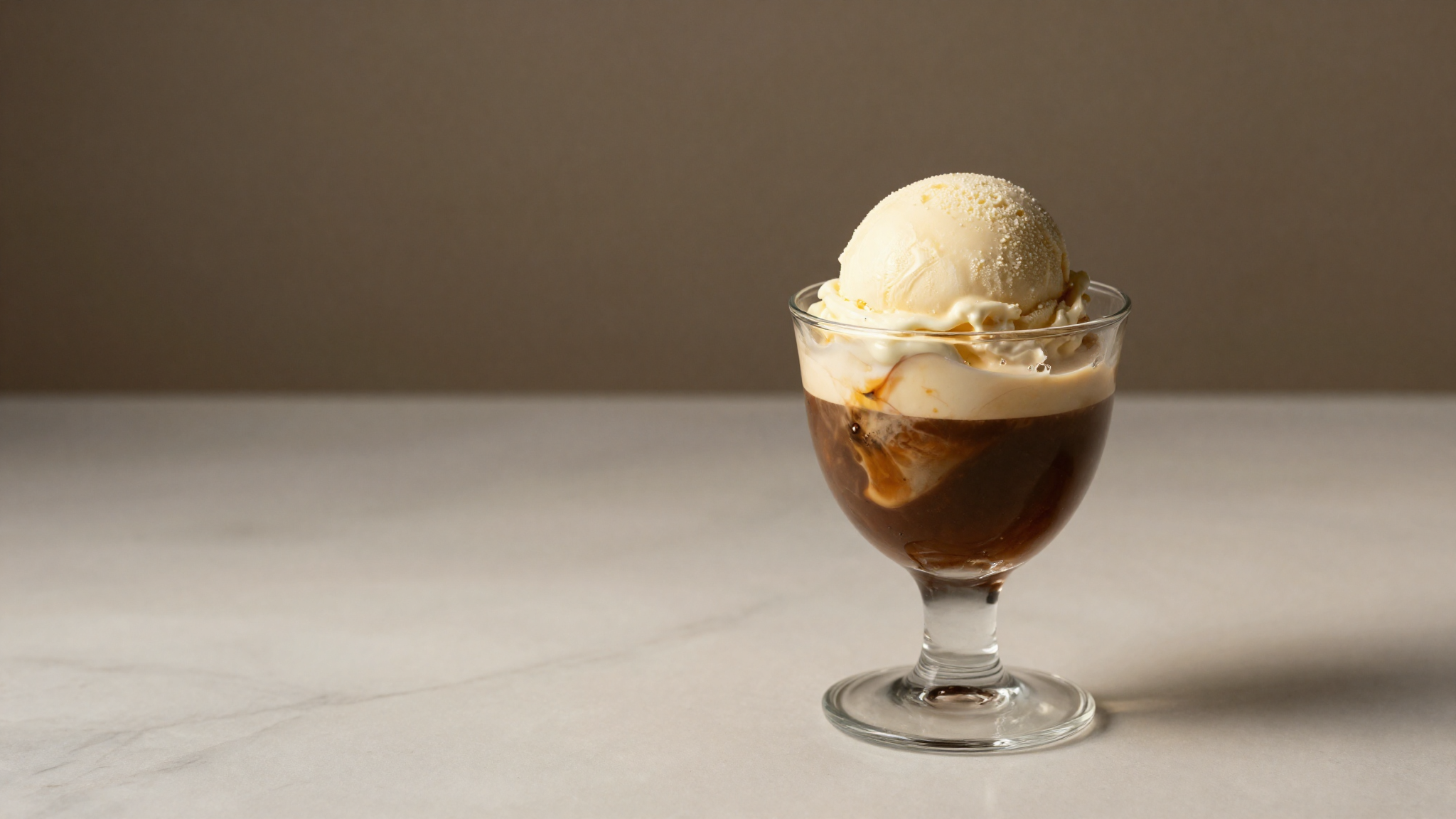 Finished affogato in a clear glass with espresso pooling around melting gelato