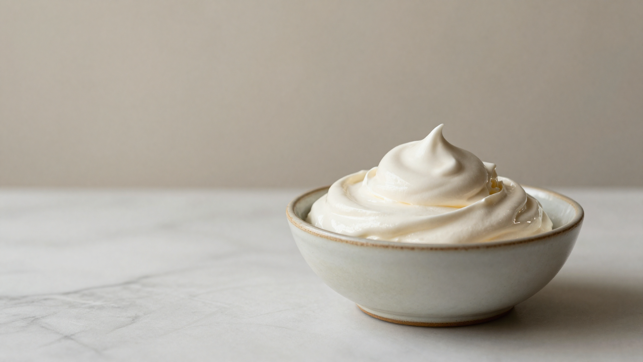 Aquafaba being whipped to soft white peaks in a bowl