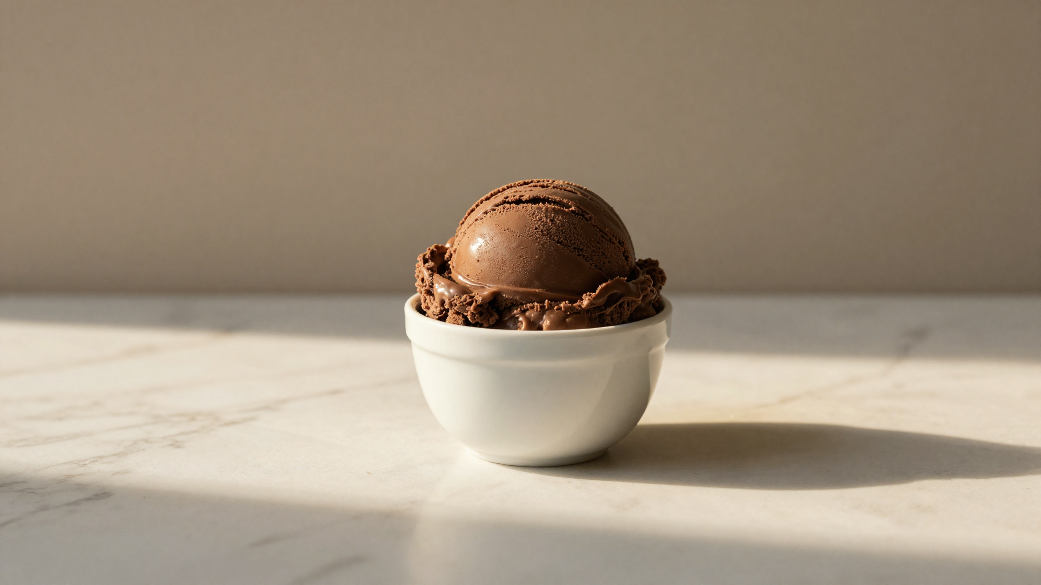 A finished scoop of rich vegan chocolate gelato in a ceramic cup