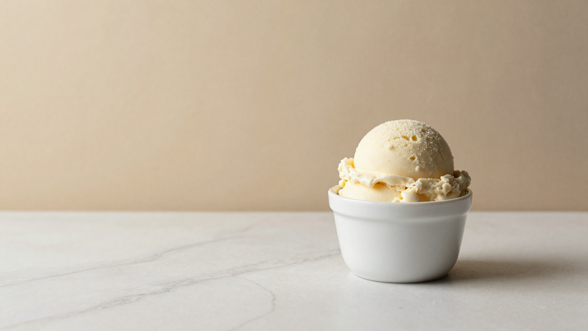 A scoop of pale ivory vegan cashew gelato in a ceramic cup