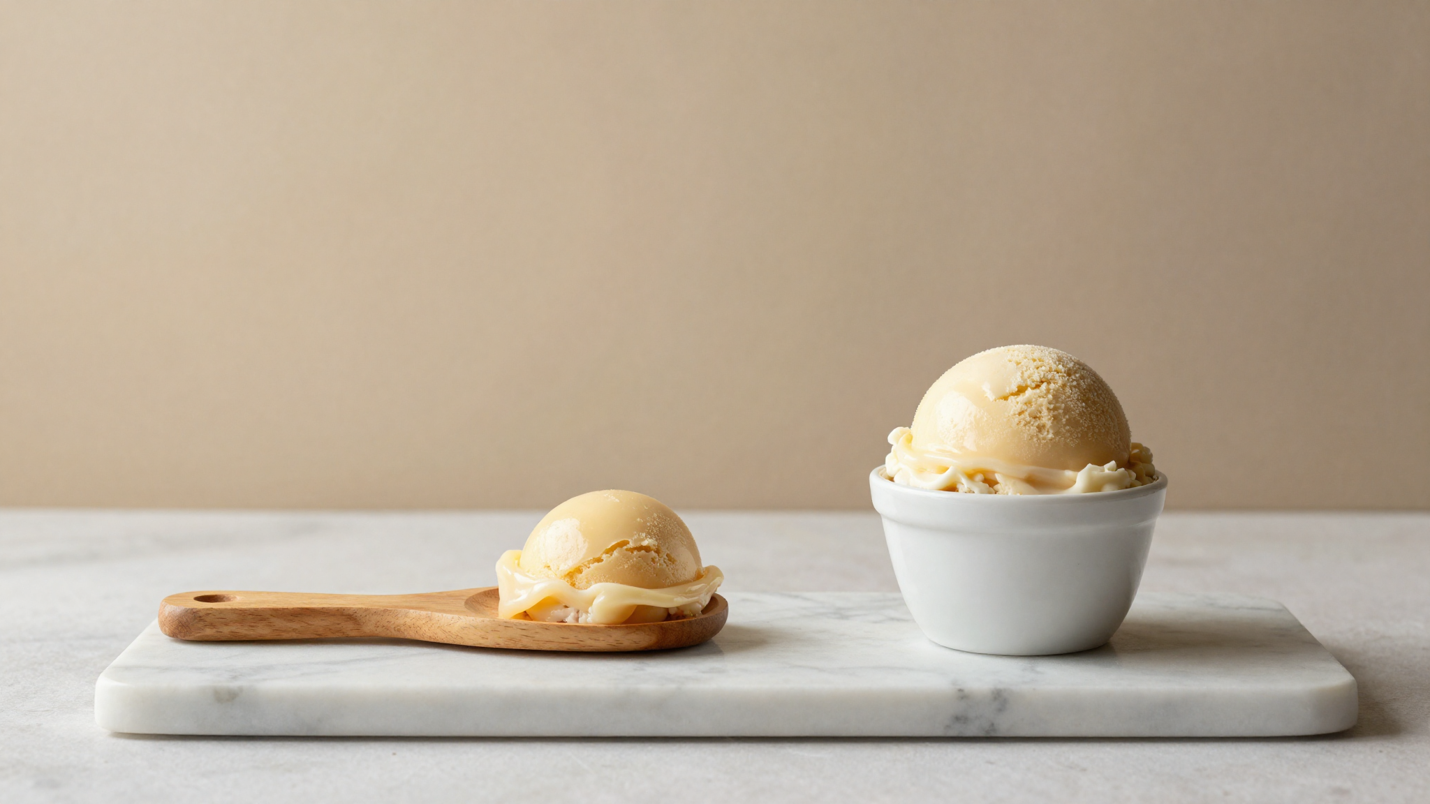 Side by side of stretchy turkish dondurma and a scoop of italian gelato on marble