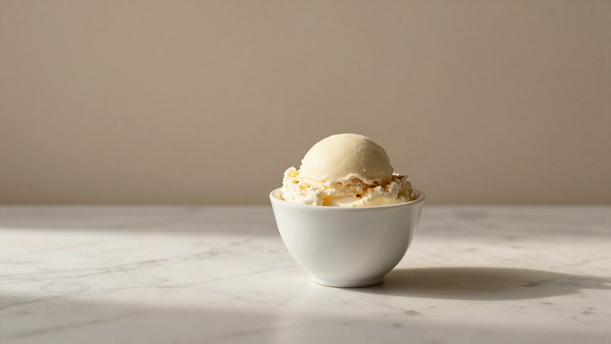 Finished white fior di latte gelato served in a ceramic cup on marble