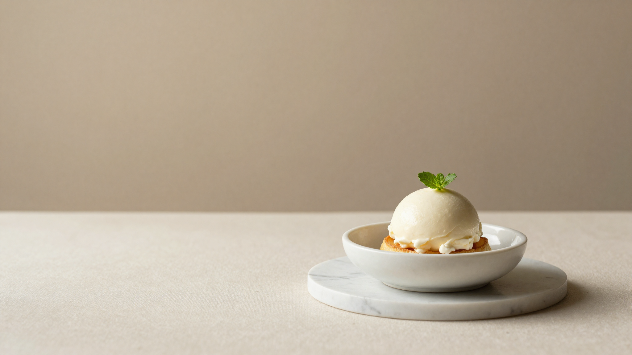 Fior di latte gelato served in a refined ceramic cup, simple garnish, marble surface