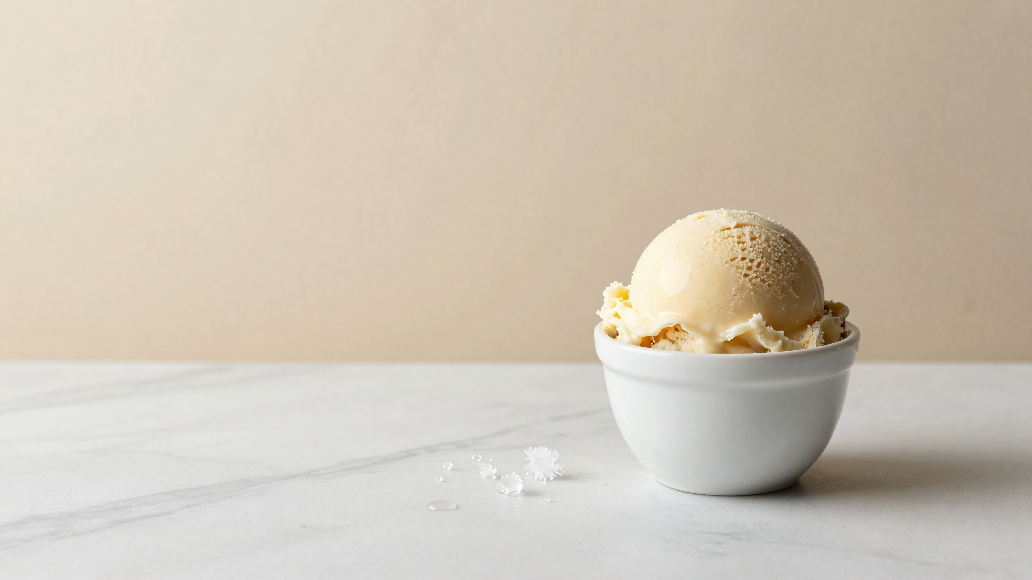 A scoop of italian gelato in a white ceramic cup on marble evoking free versus bound water