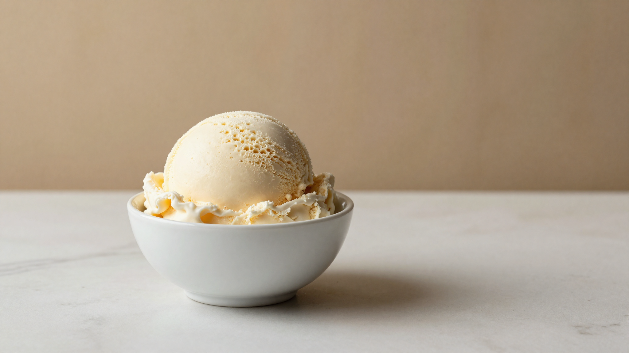 A single clean scoop of pale ivory vegan gelato showing dense smooth texture
