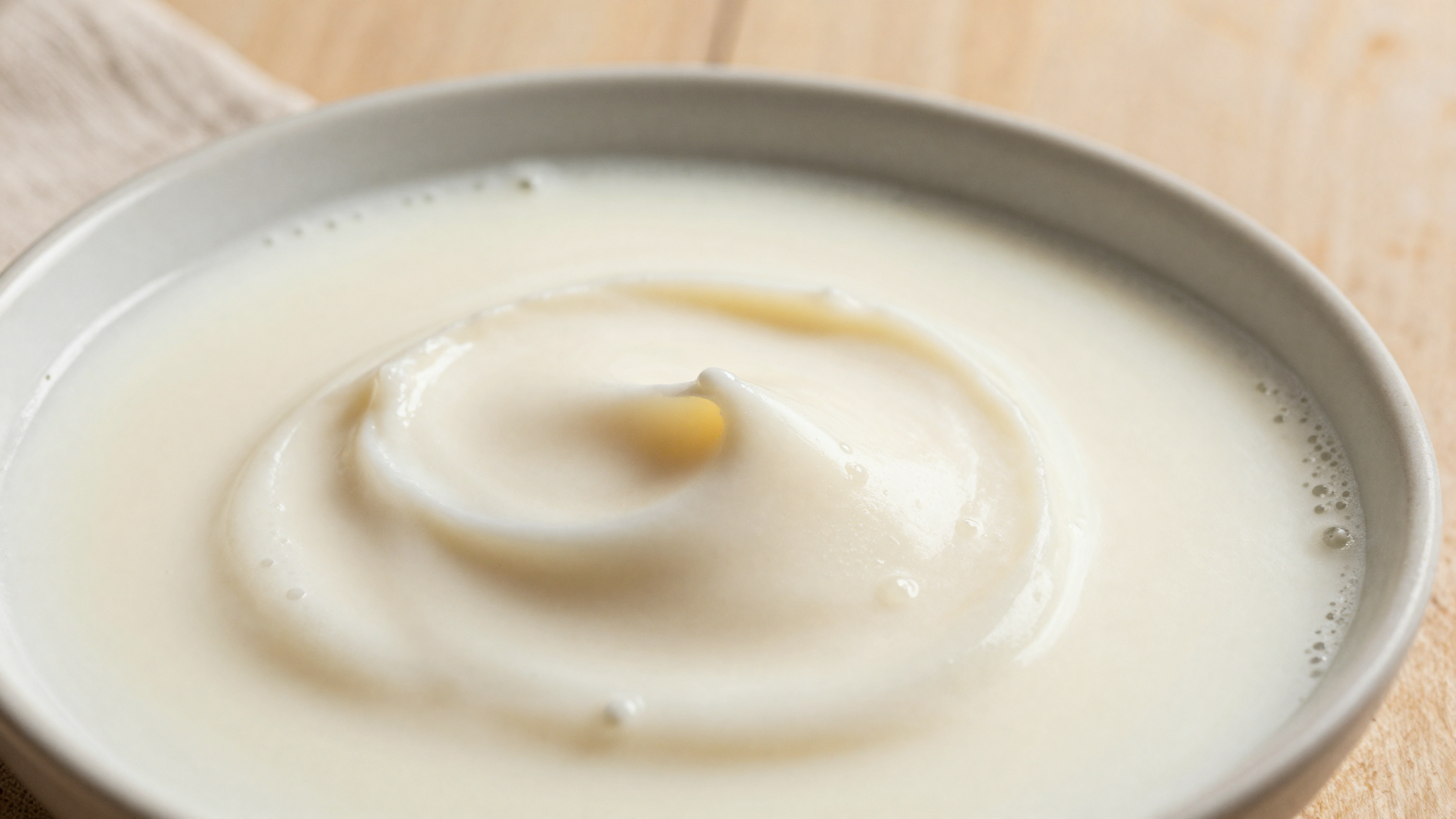 Creamy milk and cream blending into a smooth homogeneous gelato emulsion