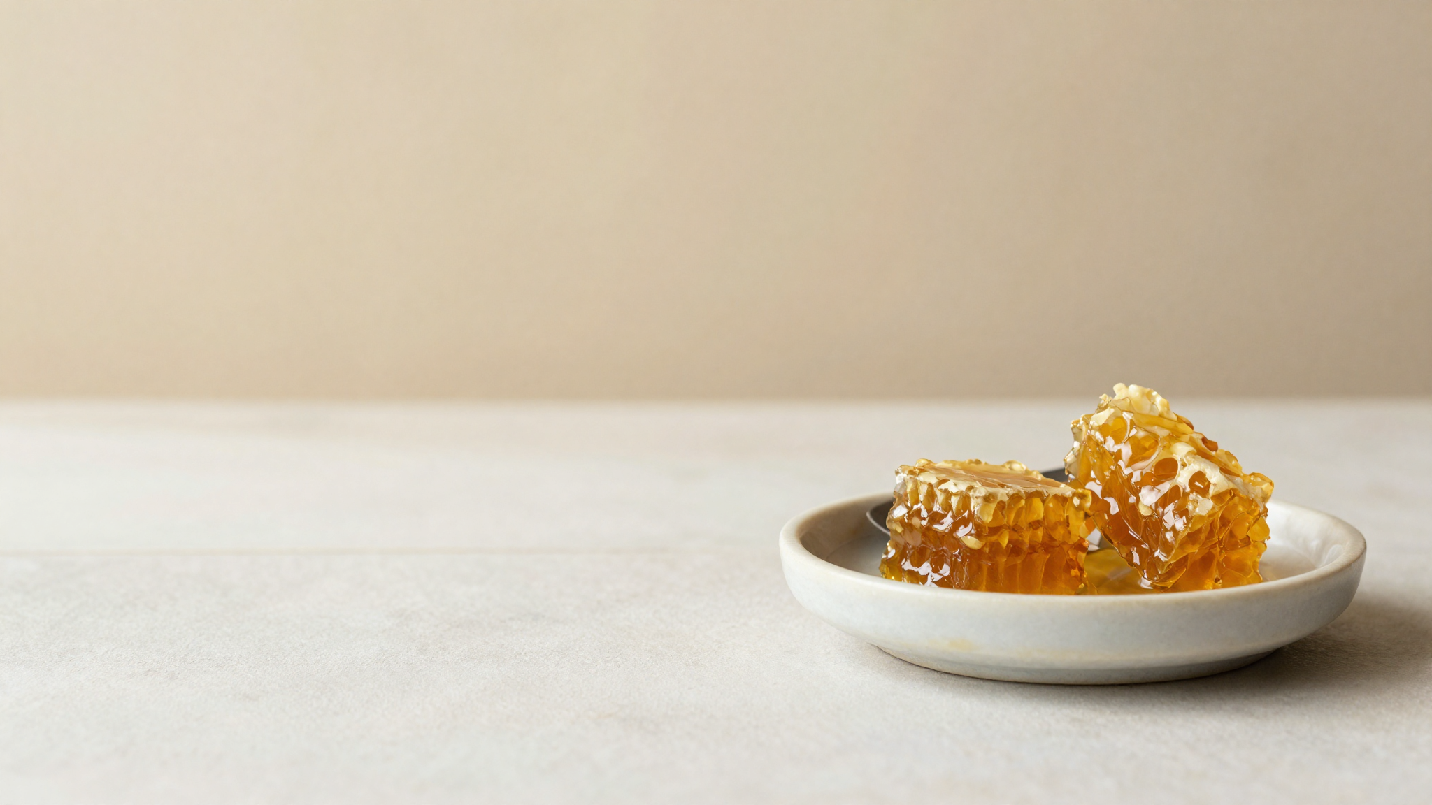 A spoonful of raw honey with honeycomb pieces on a ceramic dish
