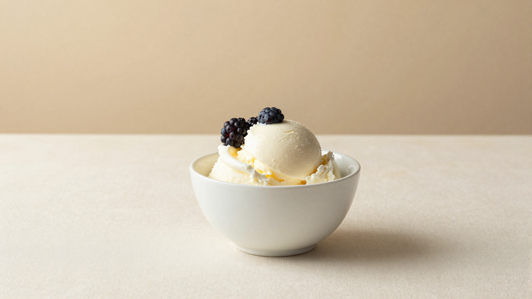 Pale cultured kefir gelato in a white ceramic cup garnished with berries