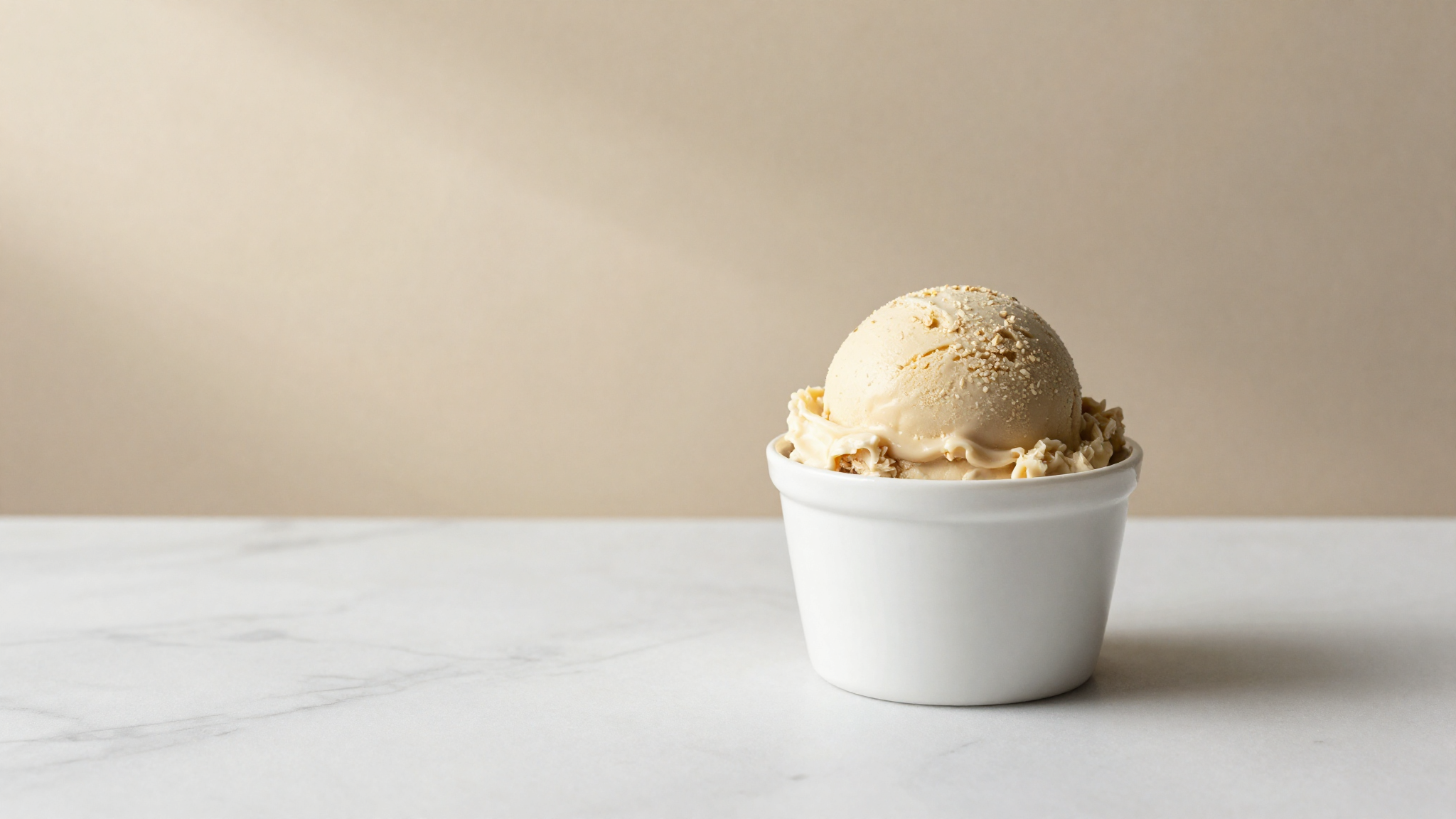 A finished vegan oat milk gelato scoop in a white ceramic cup