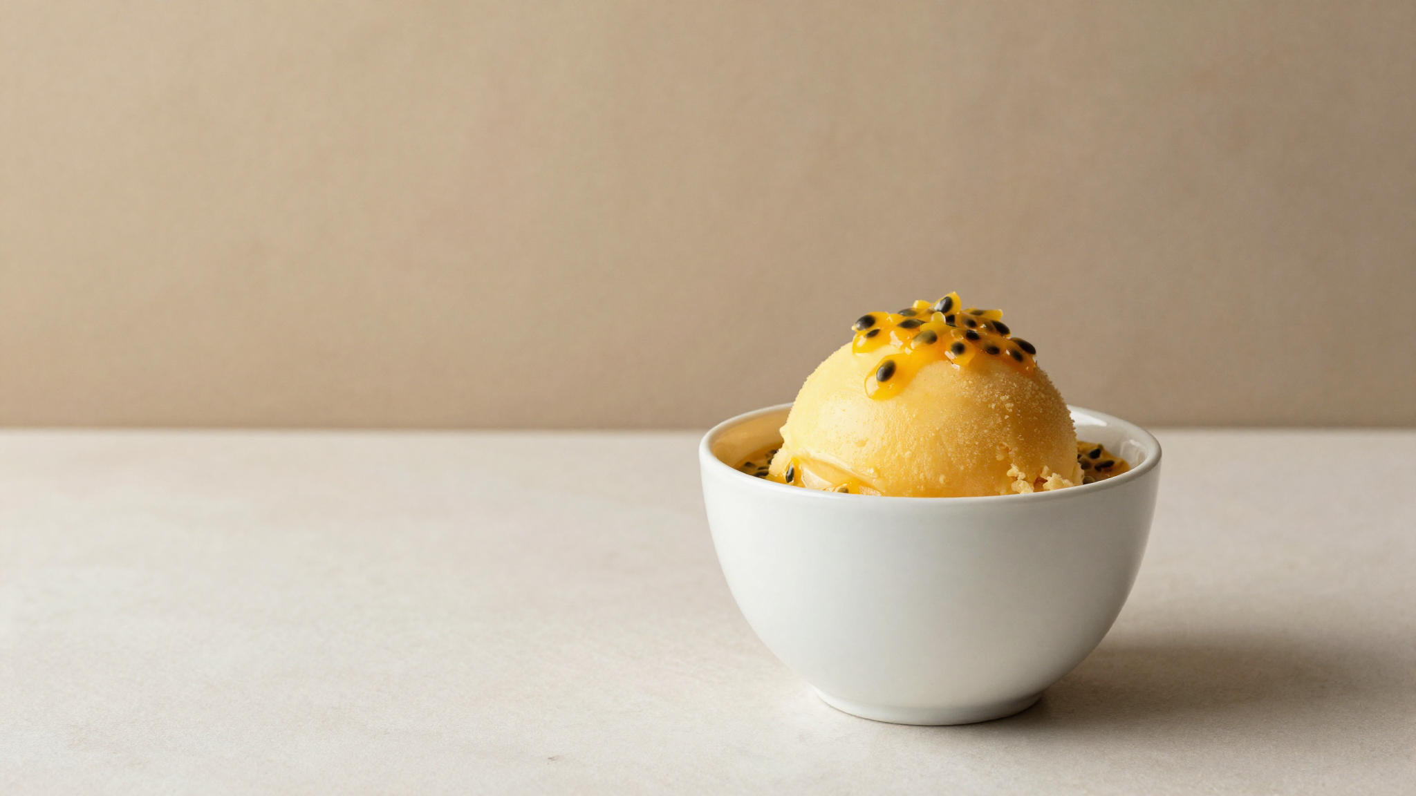 Passionfruit sorbetto in a white ceramic cup garnished with fresh pulp