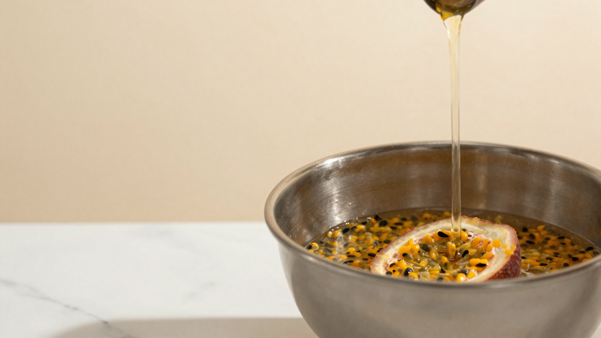 Passionfruit pulp and sugar syrup combined in a stainless bowl