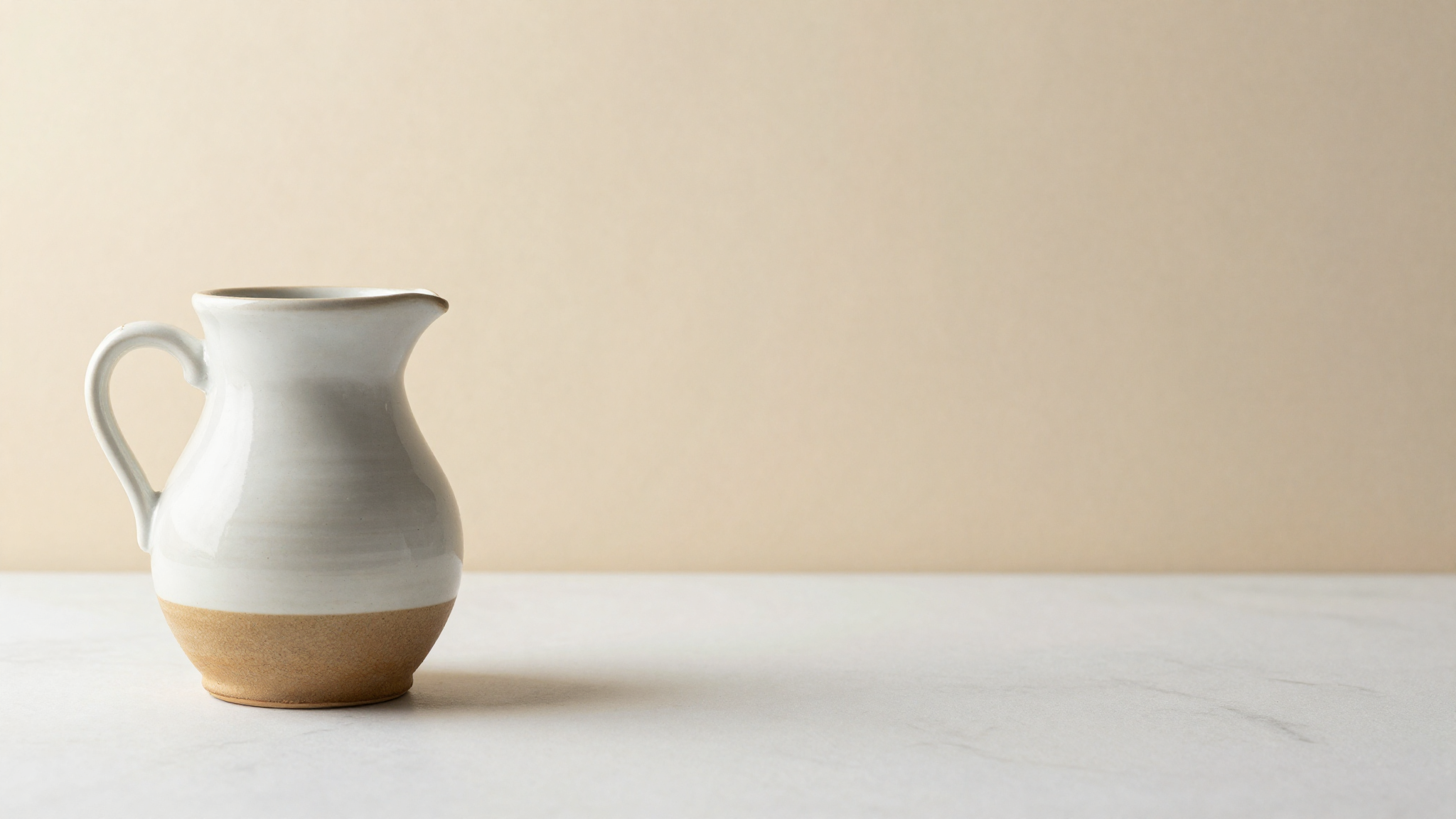 Fresh sheep milk in a ceramic jug on marble