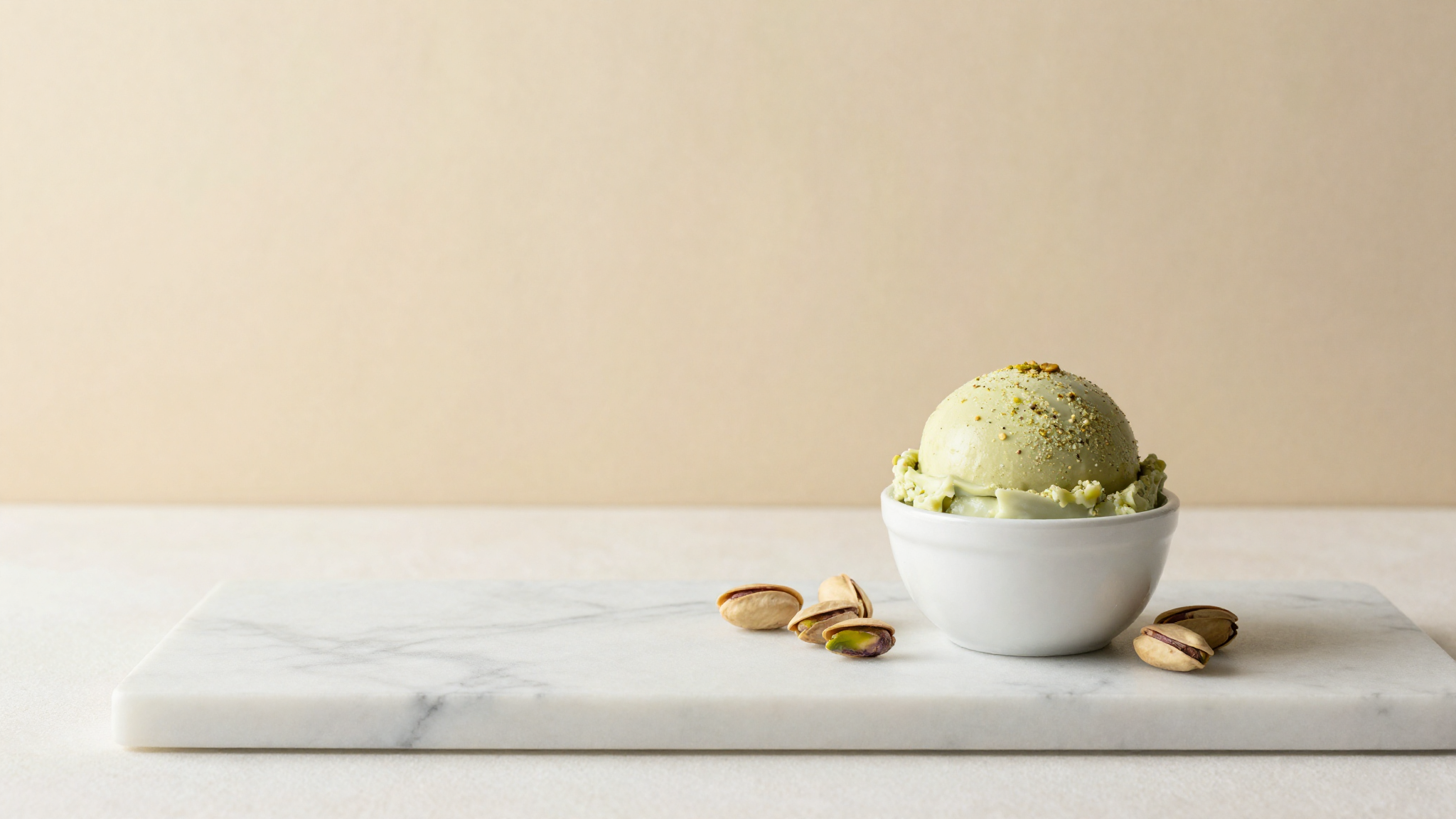 A finished scoop of pistachio gelato in a small ceramic cup on marble, styled in the clean Sicilian tradition