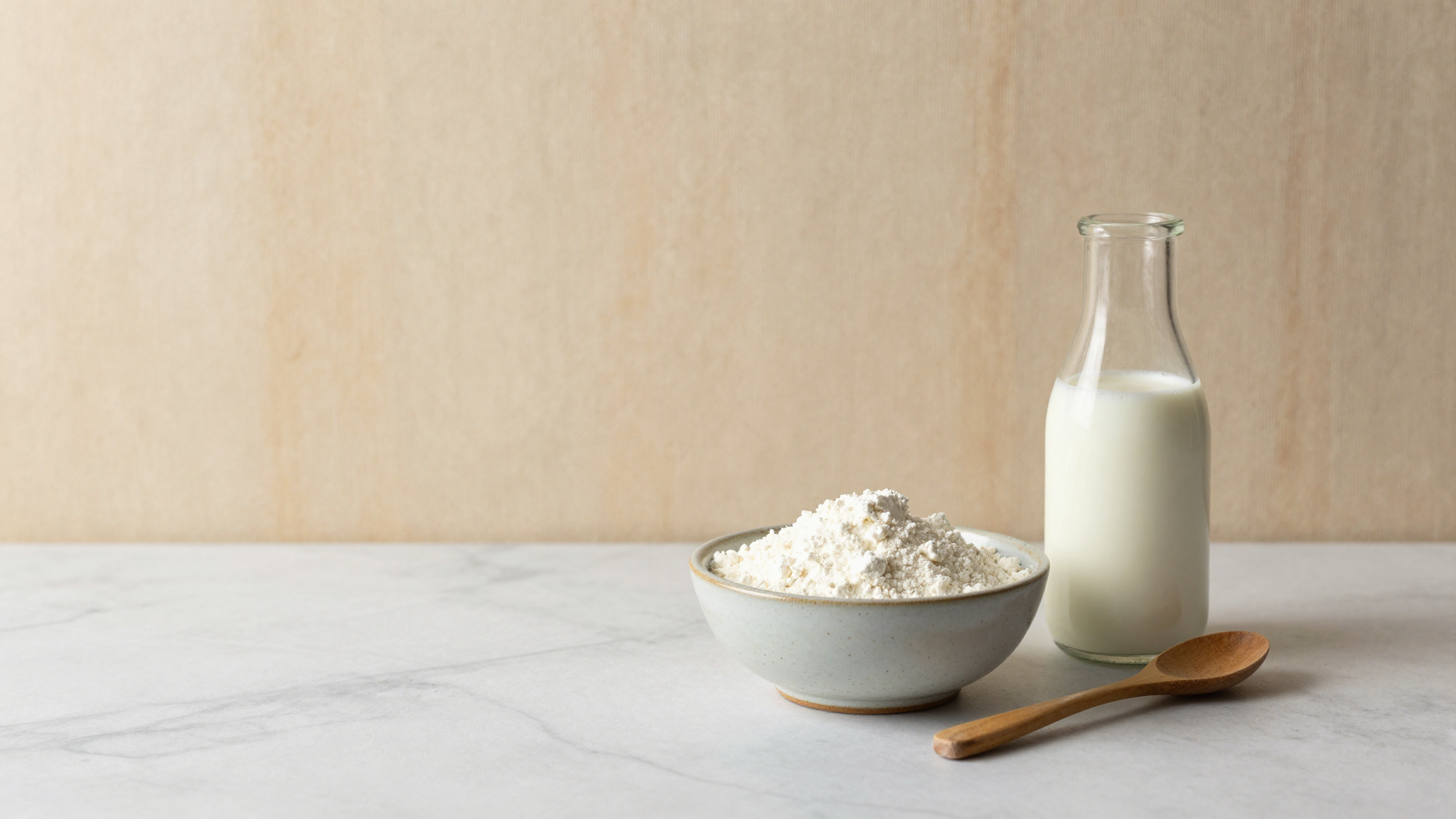 Bag of skim milk powder next to a bowl showing the fine white powder texture