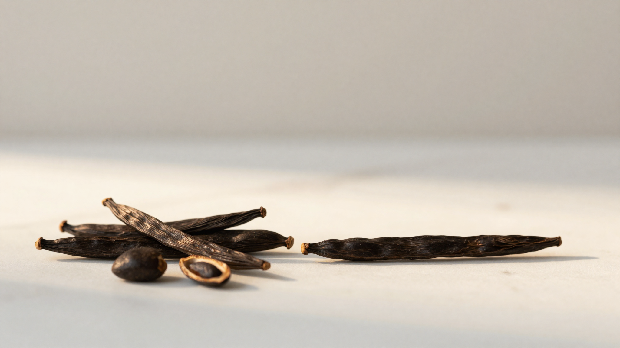 A tonka bean being grated with a microplane over a cup of gelato