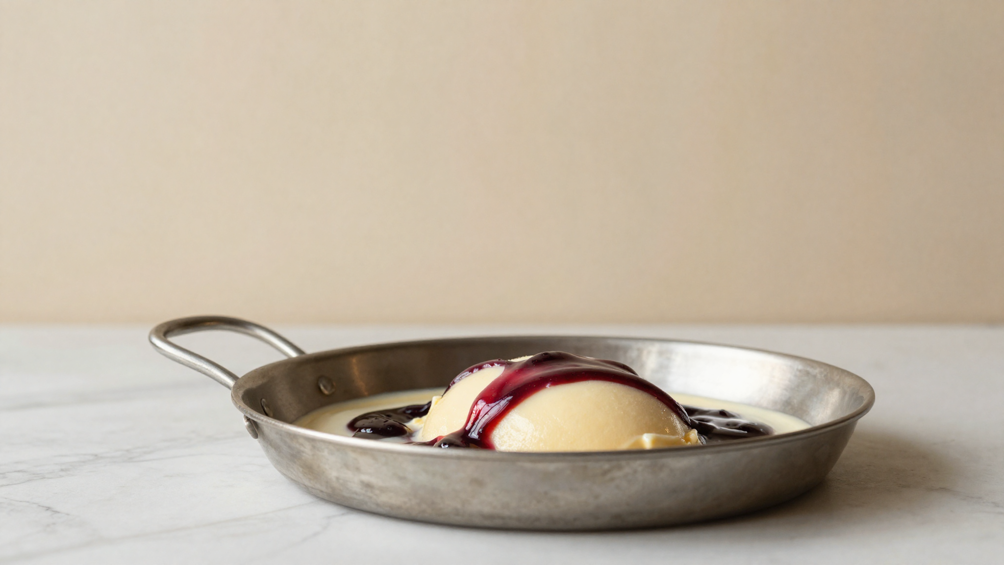 A glossy dark fruit variegate rippled through pale gelato in a stainless pan
