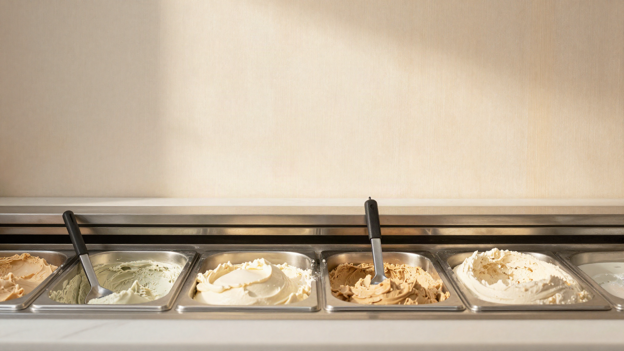 A probe thermometer resting in a steel gelato pan inside a display cabinet