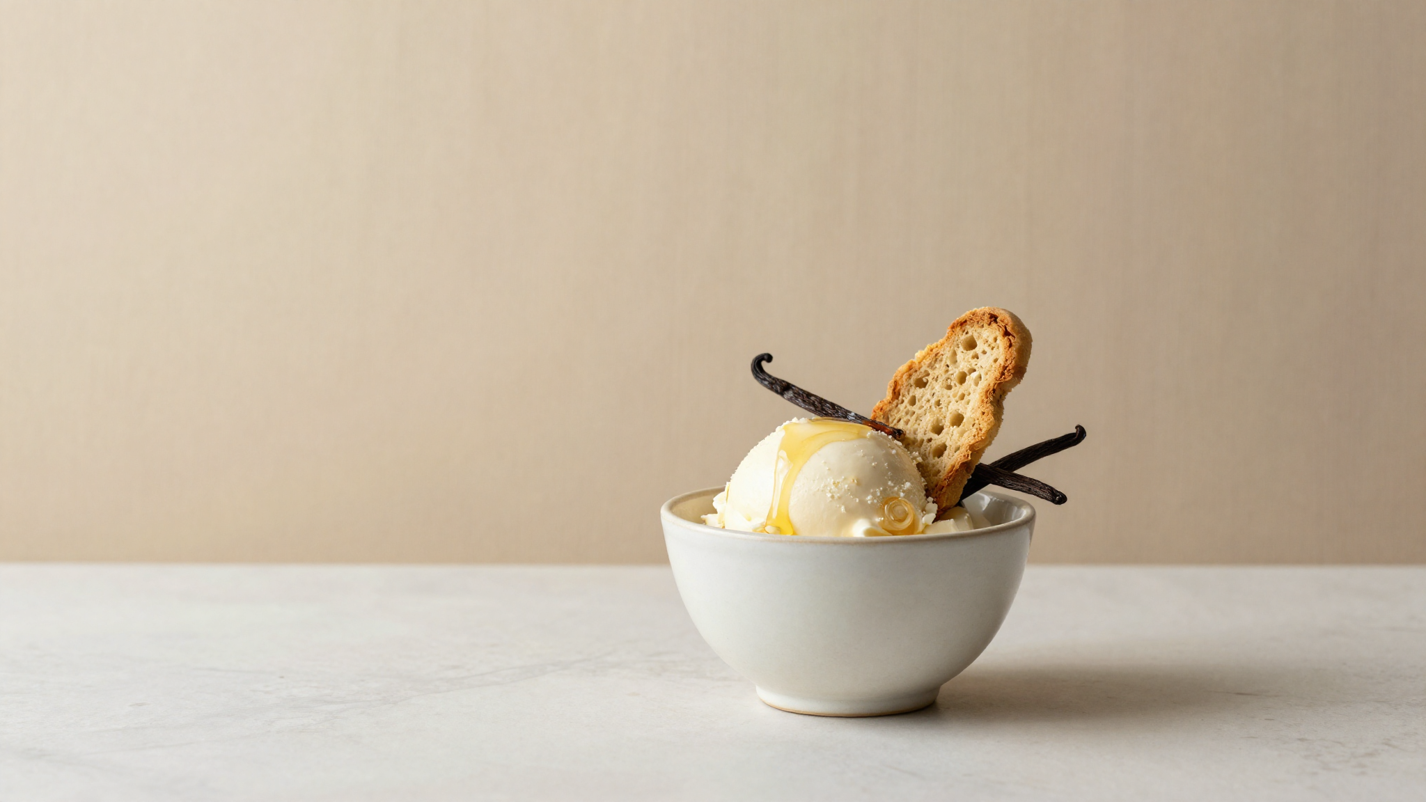 Hero photo of zabaione gelato in a refined ceramic cup with marsala wine drizzle and biscotto on marble